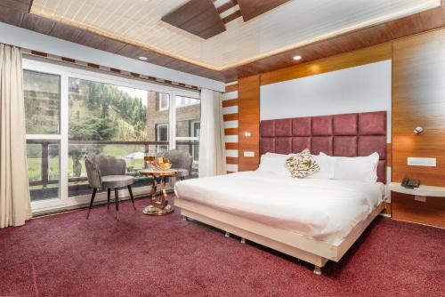 a bedroom with a large bed and a large window at Fimi hotel aru valley pahalgam in Ārau