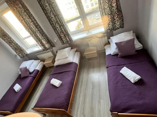 two twin beds in a room with a window at Jasna Hotelik self check-in in Warsaw