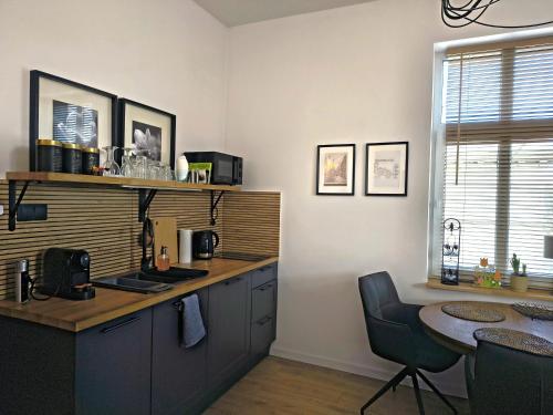 a kitchen with a counter and a table and a table at Apartament Wieżyczka in Świdnica