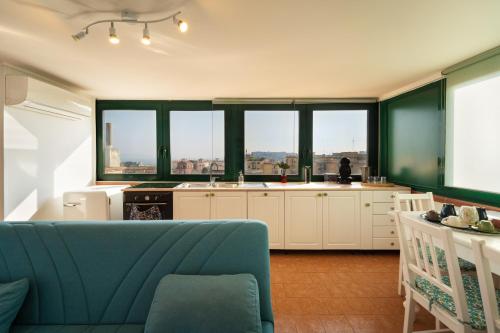 a kitchen with a blue couch and some windows at Terrazza vista Vesuvio e Capri con Jacuzzi privata in Naples