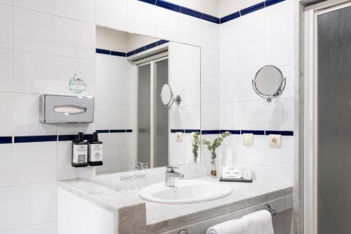 a white bathroom with a sink and a mirror at Parador de Fuente Dé in Fuente Dé