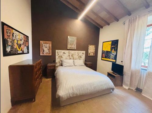 a bedroom with a bed and a dresser in it at La locanda delle pulci in Colombella