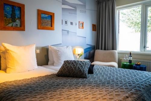 a hotel room with a bed and a window at Kruller - Hotel B&B in Otterlo
