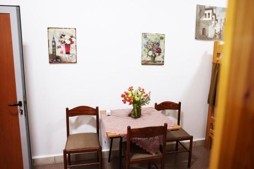 a dining room table with a vase of flowers on it at Guest House Univers in Berat