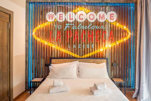 a bedroom with a bed with a sign that reads welcome to fabulous la paza at La Pacheca Rock Apartments in Lazise