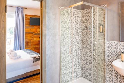 a bathroom with a shower with a sink and a bed at La Pacheca Rock Apartments in Lazise