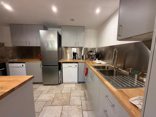 a kitchen with white cabinets and a stainless steel refrigerator at Maison Caramel Chalet in Landry