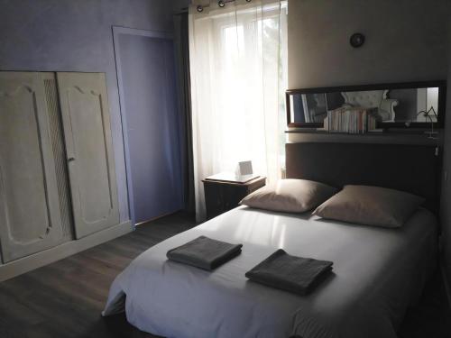 a bedroom with a bed with two towels on it at La Maison Bleue Trentemoult in Rezé