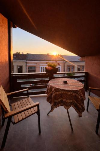 a balcony with a table and benches and a view of a building at Nesto Rooms in Sighetu Marmaţiei