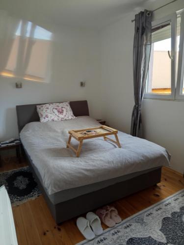 a small bedroom with a bed with a table on it at GUESTHOUSE TARA in Kolašin