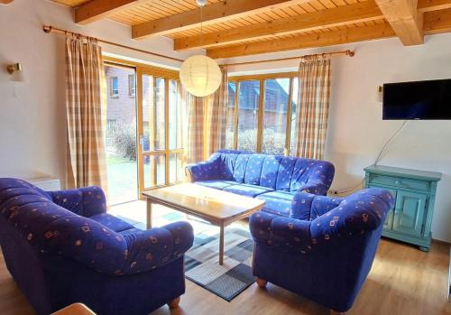 a living room with blue couches and a table at Haus 24 im Natur Ferienpark, Perfekt für Hundeliebhaber, Wanderfreunde und Naturliebhaber in Nieheim