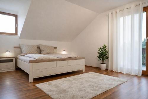 a white bedroom with a bed and a rug at Ferienhaus 147 in Sekull