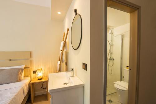 a bathroom with a sink and a toilet and a mirror at Casa Garden in Karpathos
