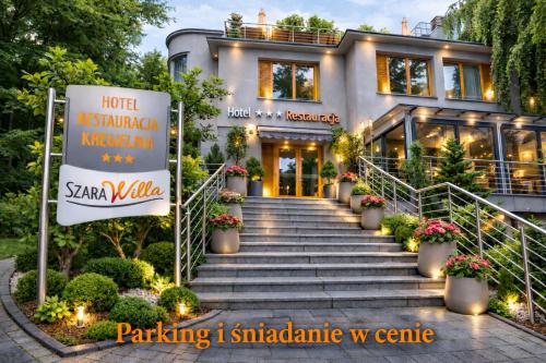 a house with a sign in front of it at Hotel Szara Willa in Opole