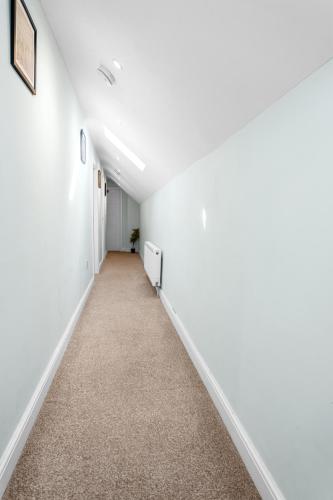 an empty hallway with white walls and carpet at Family-Friendly Chorlton Apartment with Free Street Parking in Sale
