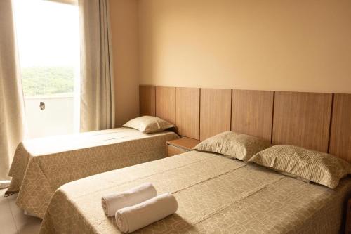 two beds in a small room with a window at Hotel Primavera Palace in Salinas