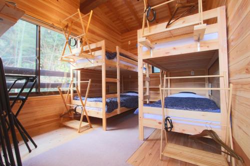 a room with two bunk beds in a cabin at Bungee Inn in Minamiizu