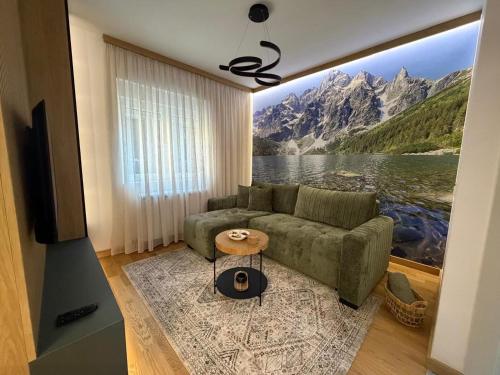 a living room with a couch and a painting of a mountain at City Garden II in Kolašin