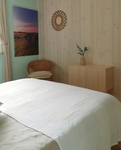 a bedroom with a white bed and a chair at TheGilgahouse Gardenroom nr 2 in Nakskov
