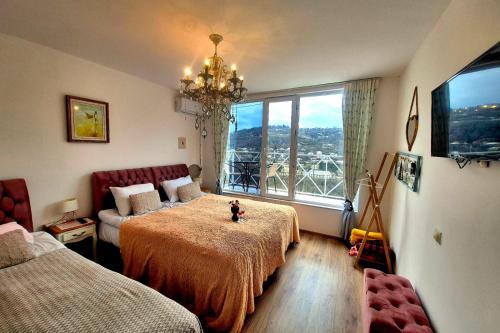 a bedroom with two beds and a couch and a window at Sighnaghi Art Hotel in Sighnaghi