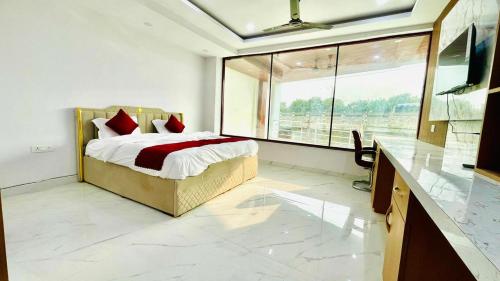 a bedroom with a bed and a large window at Sai Sansthan Inn in Lucknow