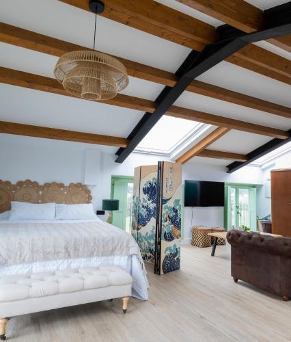 a bedroom with a bed and a ceiling with beams at El Sueño, La Perla in Barres