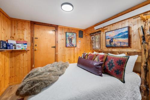 a bedroom with wooden walls and a bed with pillows at Timber Ridge Cabin: Rustic Getaway in Rapid City