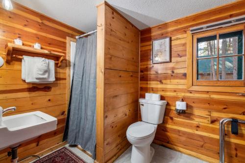 a log cabin bathroom with a toilet and a sink at Timber Ridge Cabin: Rustic Getaway in Rapid City