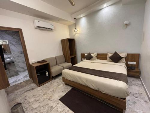 a bedroom with a large bed and a couch at Serenity By The Ganges in Haridwār