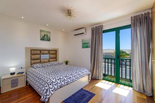 a bedroom with a bed and a balcony at Villa Sunshine Lanzarote by Villa Plus in Teguise