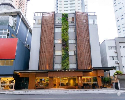 a hotel with a vertical garden on the front of it at Hotel Negrini in Balneário Camboriú