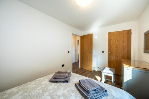 a bedroom with a bed with two towels on it at Annabella Cottages in Crossford