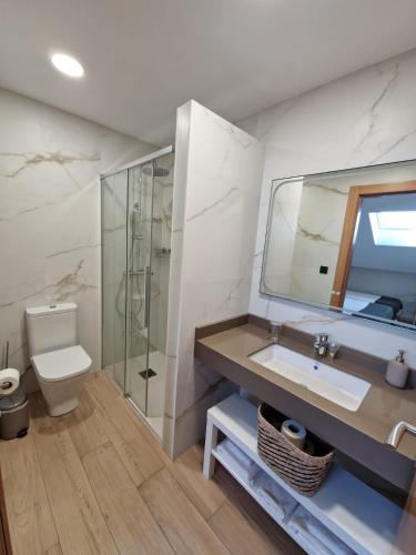 ein Badezimmer mit Waschbecken, Toilette und Spiegel in der Unterkunft Hotel El Balcón in Avilés