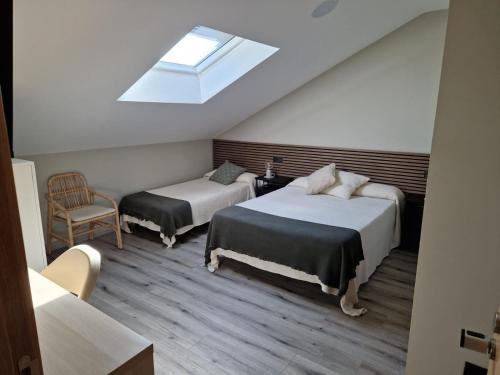 ein Schlafzimmer mit zwei Betten und einem Dachfenster in der Unterkunft Hotel El Balcón in Avilés