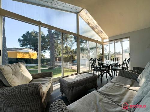 a living room with large windows and a table and chairs at Villa Las Palmas in Benicàssim