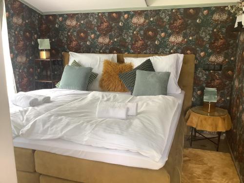 a bed with white sheets and pillows in a bedroom at Apartmány Javorek in Sněžné