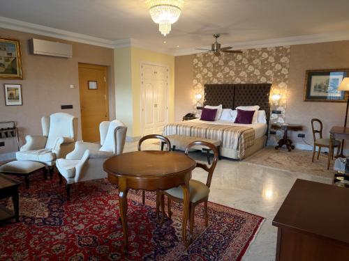 a bedroom with a bed and a table and chairs at Los Cinco Enebros Hotel & Spa by Bossh! Hotels in Robledo de Chavela