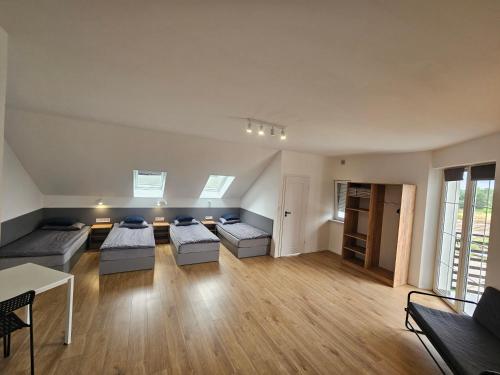 a large living room with two beds and a table at Milten Pniów in Pniów