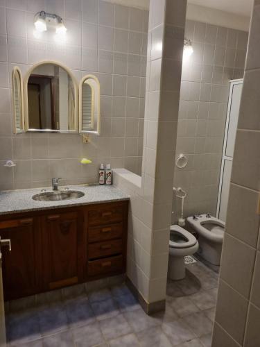 a bathroom with a sink and a toilet and a mirror at Casa a metros de todo in Federación