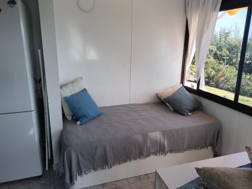 a small bed in a room with a window at Monte Rojo San Agustin in San Agustin