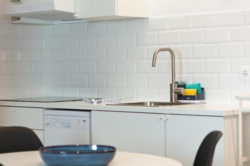 a kitchen counter with a sink and a bowl on a table at OportoWaves in Matosinhos