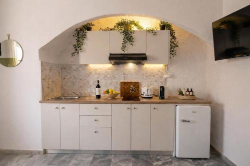 a kitchen with white cabinets and a sink at Michele Marie apts in Agia Pelagia