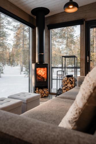 a living room with a fireplace and a couch at WALD Villas - Aavasaksa, Lapland in Aavasaksa