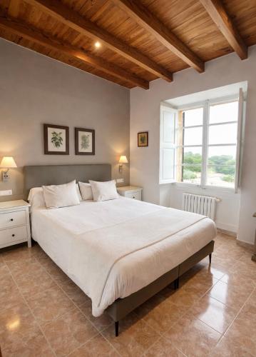 a large bed in a bedroom with a large window at Agroturisme Sa Torre, Adults Only Relax Oasis in Santa Eugenia