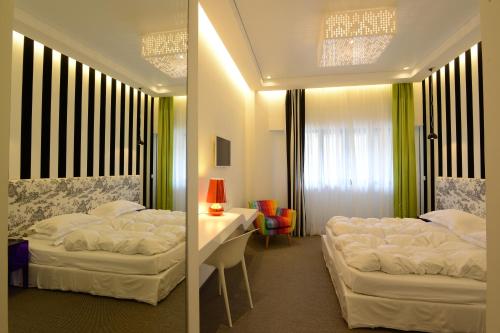 a bedroom with two beds and a table with a chair at Miramar Hotel Resort and Spa in Trâblous