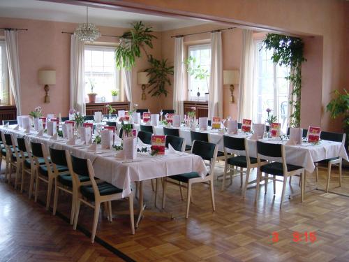 uma fila de mesas e cadeiras num quarto em Hotel Schmidt em Selb
