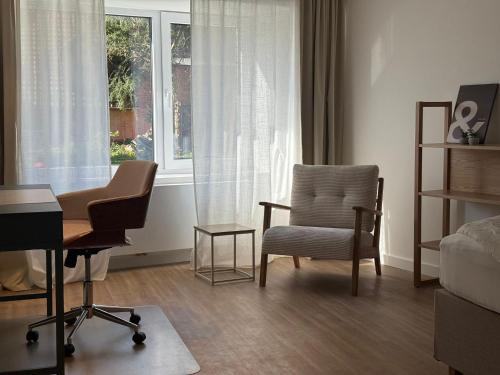a living room with a chair and a desk and a window at Superior Apartment mit 1 Schlafzimmer in Hildesheim
