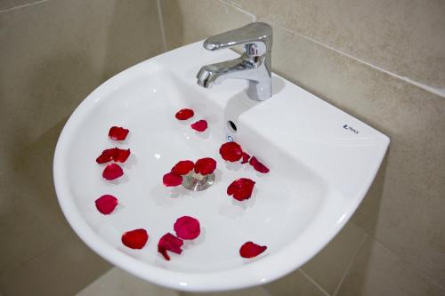 a white sink with red roses in it at Golden Bee Homestay in Hoi An