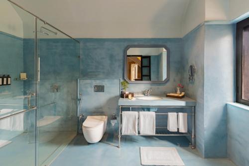 a bathroom with a sink and a shower and a toilet at lebua Udaipur Daulatgarh in Udaipur