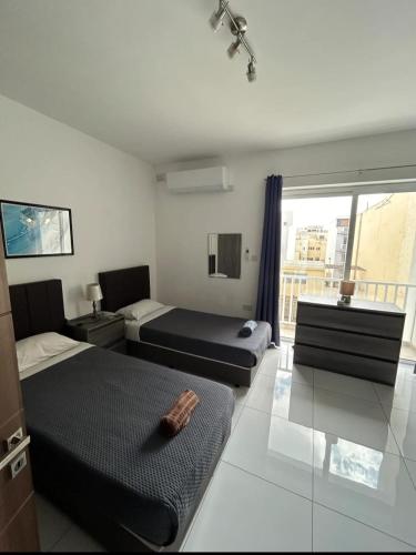 a hotel room with two beds and a window at Park Lane Experience Apartments in Il-Gżira